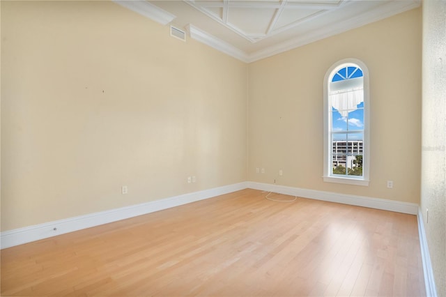 spare room with ornamental molding, light hardwood / wood-style flooring, and coffered ceiling