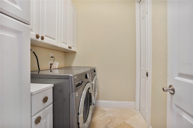 washroom with washing machine and dryer and cabinets