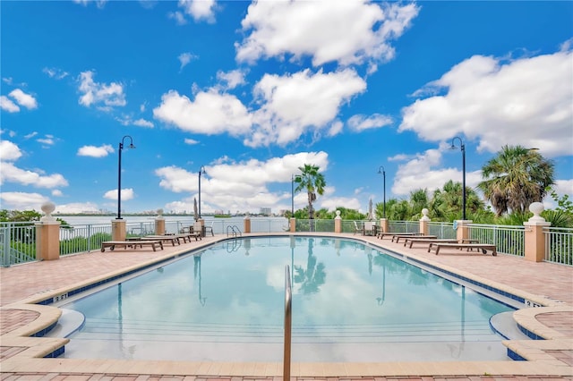 view of pool featuring a patio area and a water view