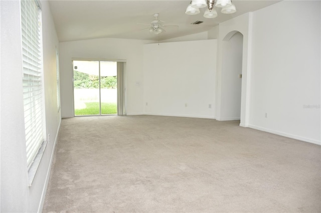 empty room with lofted ceiling, light colored carpet, and ceiling fan