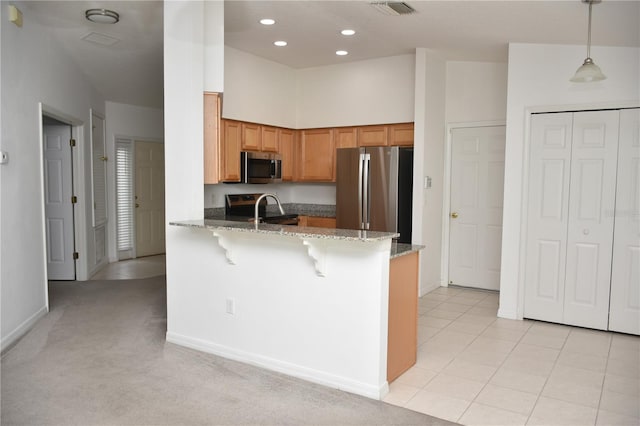 kitchen with light carpet, kitchen peninsula, a breakfast bar area, pendant lighting, and stainless steel appliances