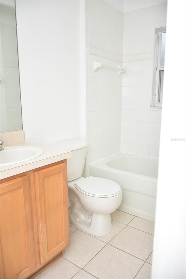 full bathroom featuring tiled shower / bath, vanity, toilet, and tile patterned flooring