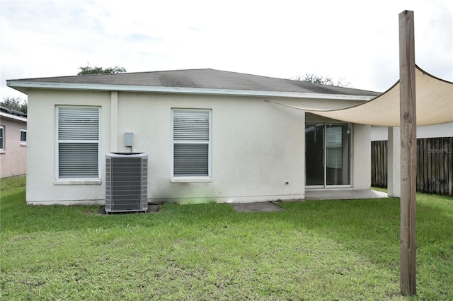 back of house featuring central air condition unit and a yard