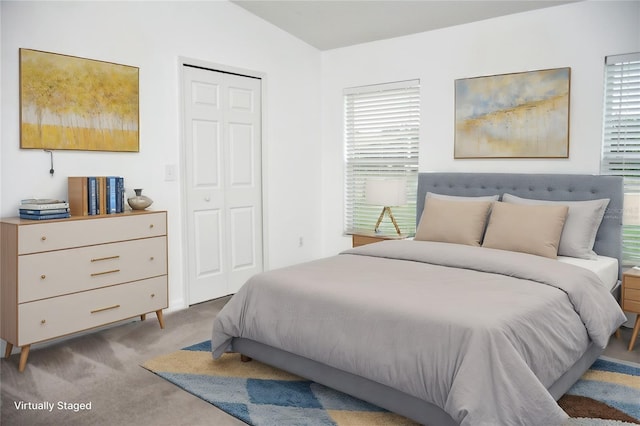 bedroom with a closet, light carpet, and lofted ceiling