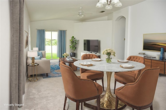 carpeted dining space featuring vaulted ceiling and ceiling fan