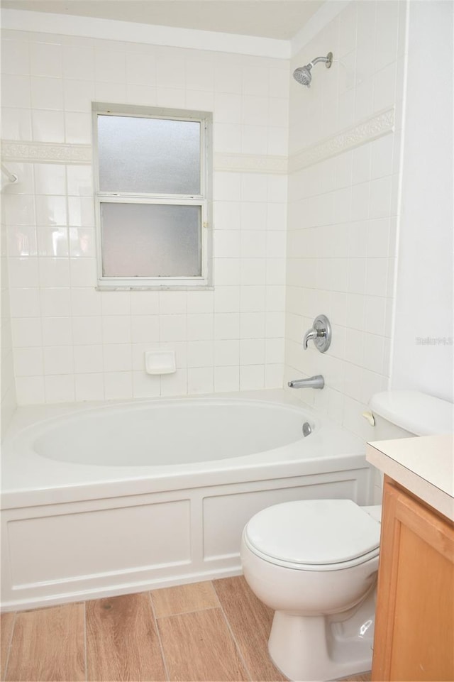 full bathroom featuring vanity, tiled shower / bath combo, and toilet