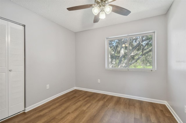 unfurnished bedroom featuring ceiling fan, a textured ceiling, a closet, and hardwood / wood-style floors