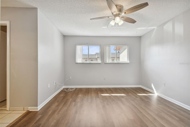 unfurnished room with hardwood / wood-style flooring and a textured ceiling