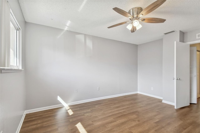 spare room with ceiling fan, hardwood / wood-style flooring, and a textured ceiling