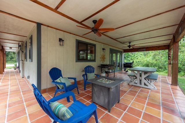 view of patio / terrace featuring ceiling fan, outdoor dining space, and an outdoor fire pit