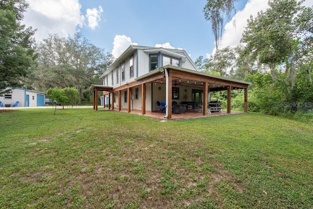 rear view of house with a lawn and a patio area