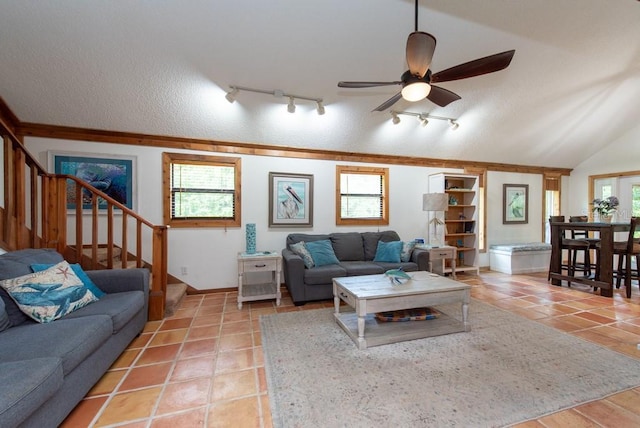 living room with rail lighting, vaulted ceiling, ceiling fan, a textured ceiling, and light tile patterned flooring