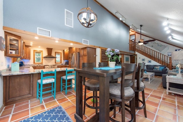 dining room featuring light tile patterned floors, ceiling fan with notable chandelier, high vaulted ceiling, and sink