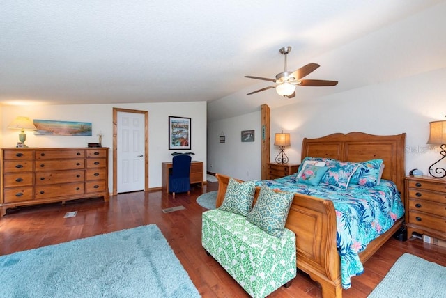 bedroom featuring dark hardwood / wood-style flooring, vaulted ceiling, and ceiling fan