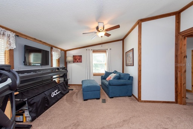 living area with ceiling fan, crown molding, light colored carpet, a textured ceiling, and vaulted ceiling