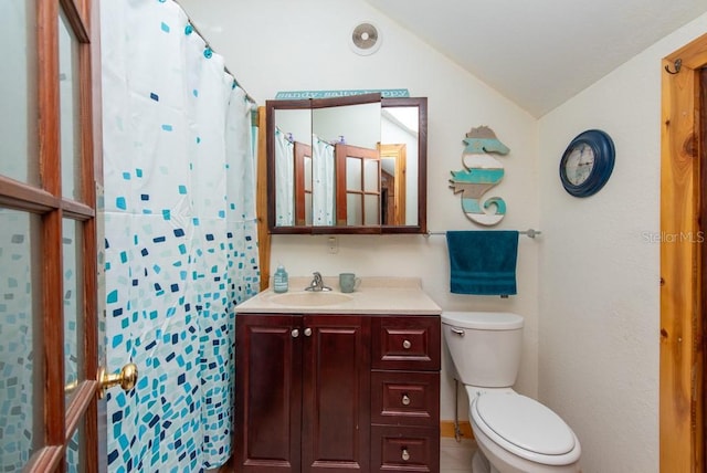 bathroom featuring walk in shower, vanity, vaulted ceiling, tile patterned flooring, and toilet