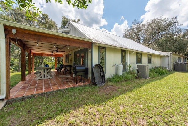 back of house with a lawn, a patio area, ceiling fan, and cooling unit