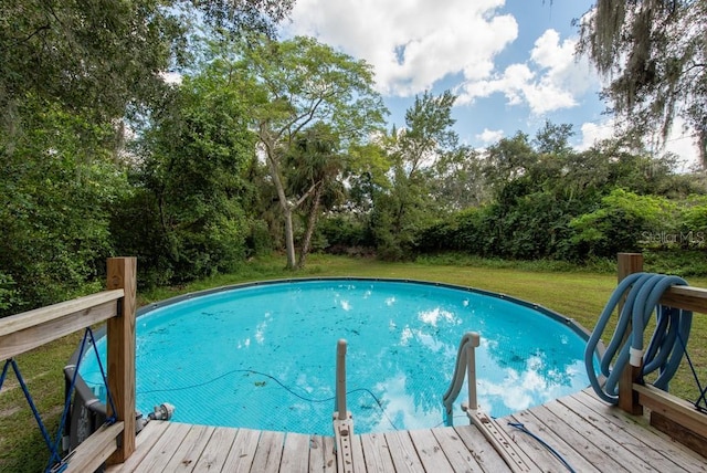 view of swimming pool with a yard and a wooden deck