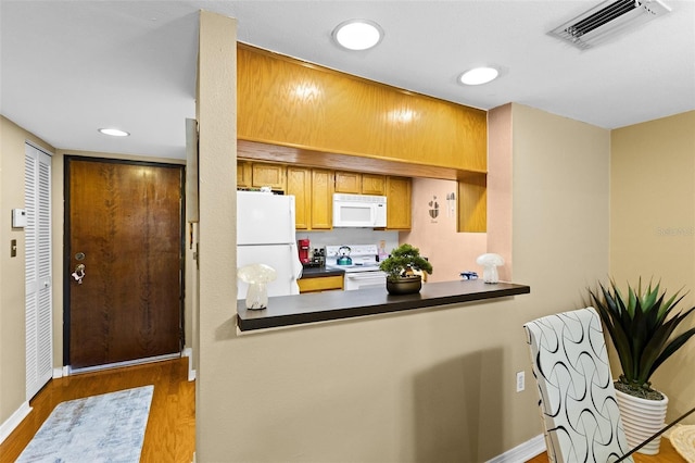 kitchen with light wood-type flooring and white appliances