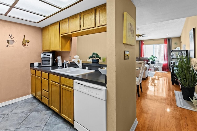 kitchen featuring white dishwasher, light wood-type flooring, a textured ceiling, ceiling fan, and sink