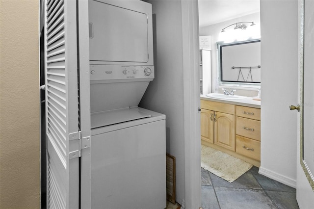 washroom with stacked washer and dryer, light tile patterned floors, and sink