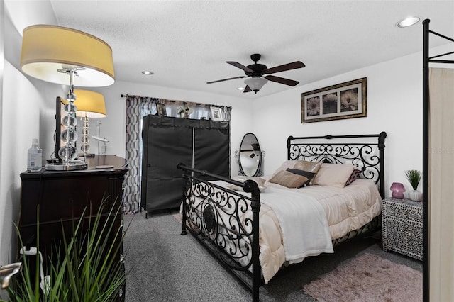 bedroom featuring ceiling fan, a textured ceiling, and carpet