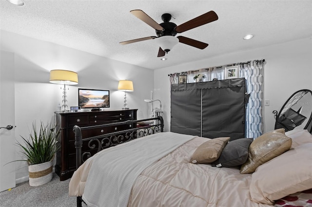 carpeted bedroom featuring a textured ceiling and ceiling fan