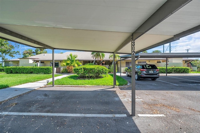 view of parking with a lawn and a carport