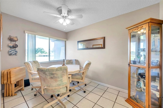 tiled dining area featuring ceiling fan and a textured ceiling