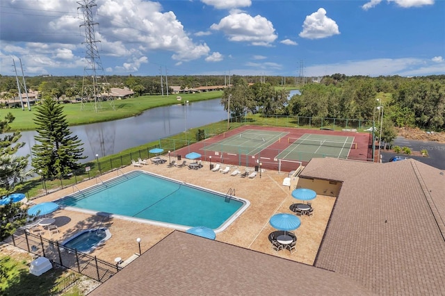 view of swimming pool with a patio, a water view, and tennis court