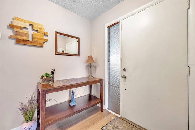 entrance foyer with a textured ceiling and light wood-type flooring