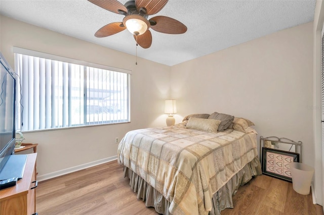 1308 13th Cir SE, Largo, FL 33771 - bedroom featuring light wood-style floors, a textured ceiling, baseboards, and ceiling fan