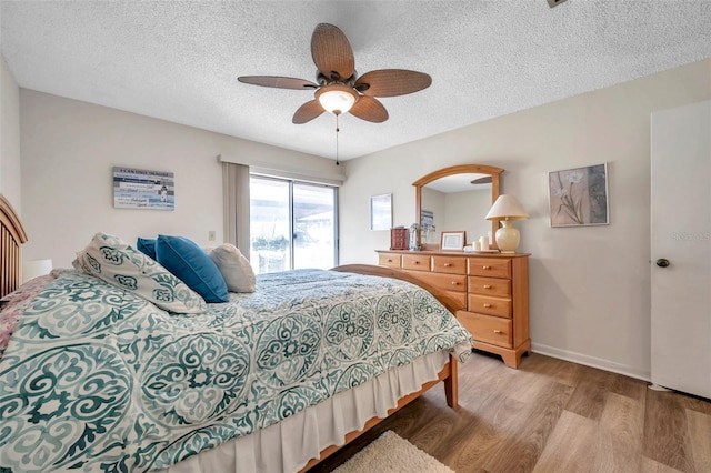 bedroom featuring a textured ceiling, wood-type flooring, and ceiling fan