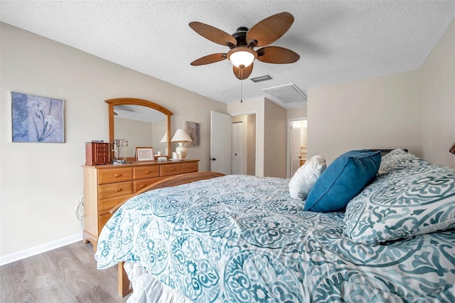 bedroom featuring a textured ceiling, light hardwood / wood-style floors, and ceiling fan