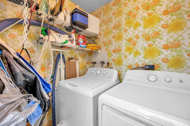 laundry area with independent washer and dryer and a textured ceiling