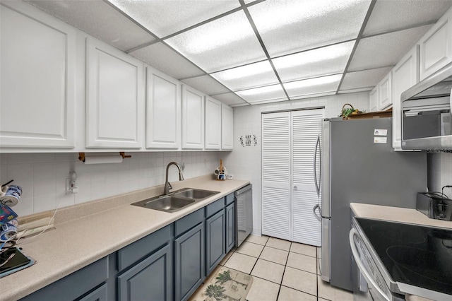 kitchen featuring white cabinetry, light tile patterned flooring, appliances with stainless steel finishes, and sink