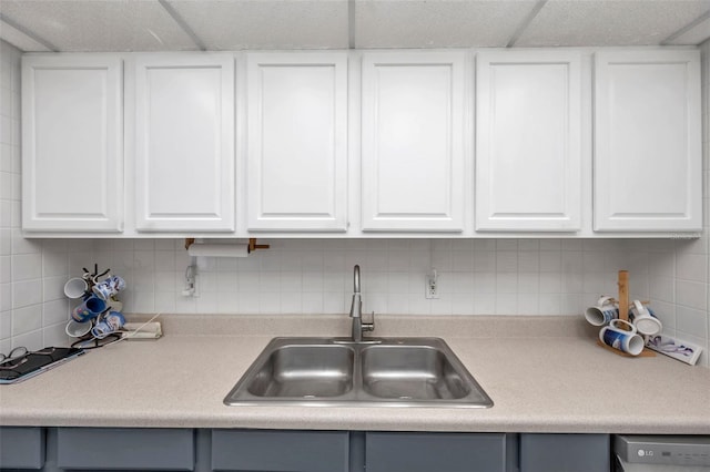 kitchen featuring sink, white cabinets, and backsplash