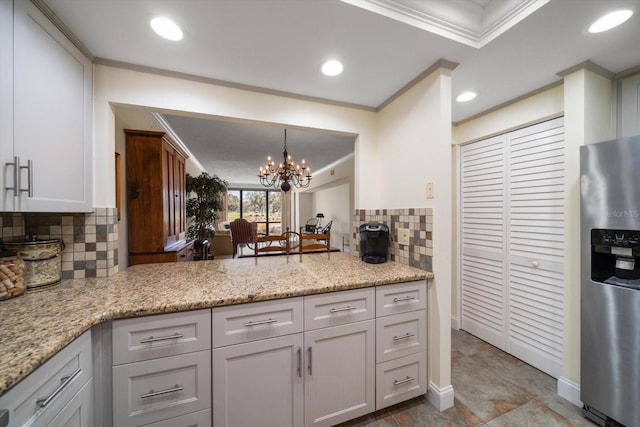 kitchen with backsplash, ornamental molding, an inviting chandelier, and stainless steel refrigerator with ice dispenser