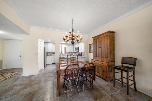 dining room with ornamental molding, a textured ceiling, and a chandelier