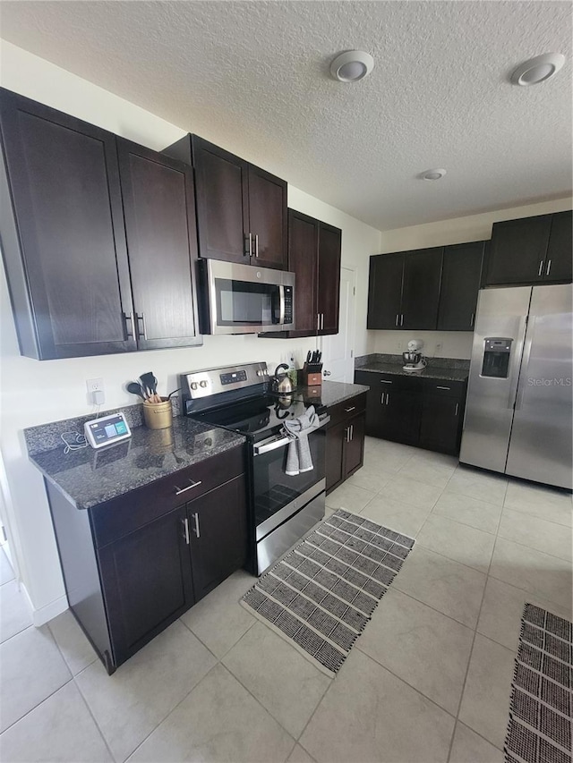 kitchen featuring appliances with stainless steel finishes, a textured ceiling, and light tile patterned floors