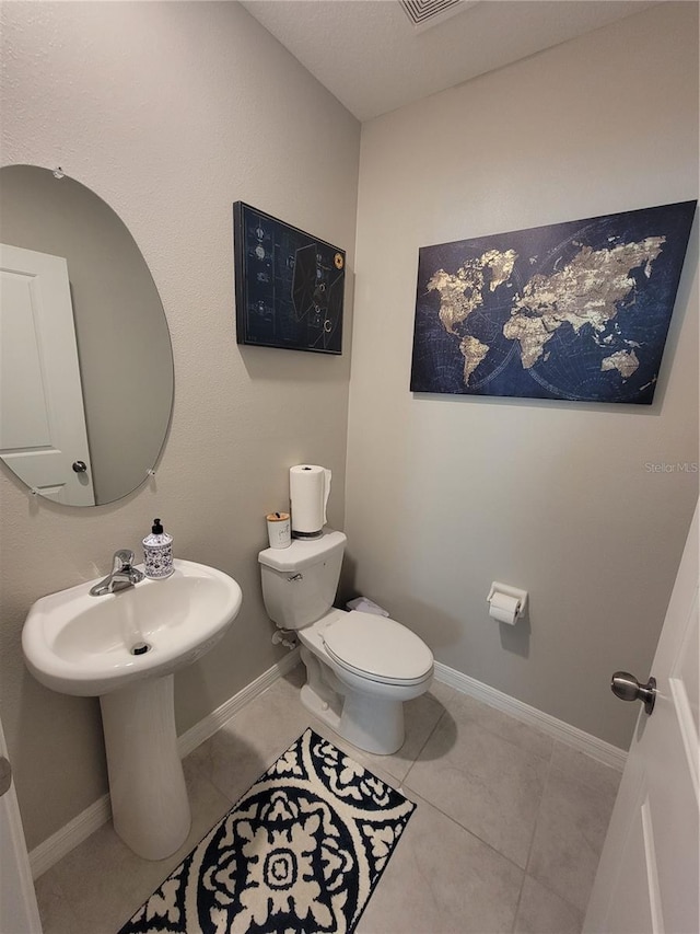 bathroom with toilet and tile patterned floors