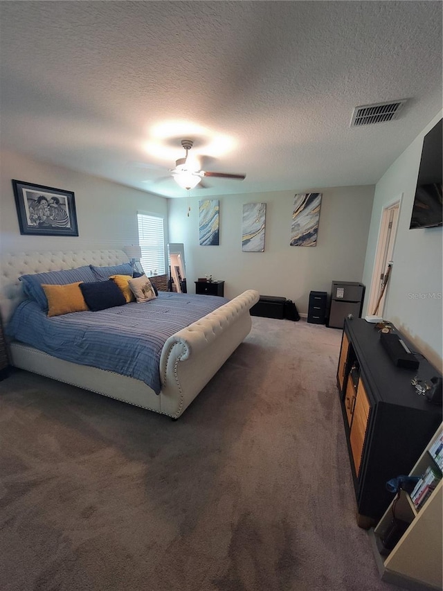 carpeted bedroom featuring ceiling fan and a textured ceiling