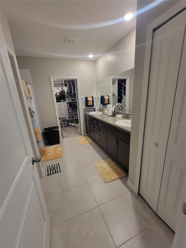 bathroom featuring vanity, tile patterned flooring, and a textured ceiling