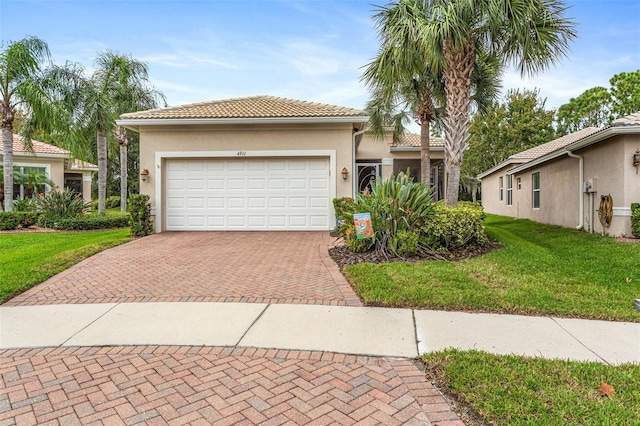 mediterranean / spanish-style house featuring a garage and a front lawn