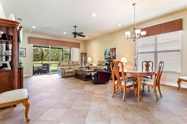 tiled dining space featuring ceiling fan with notable chandelier