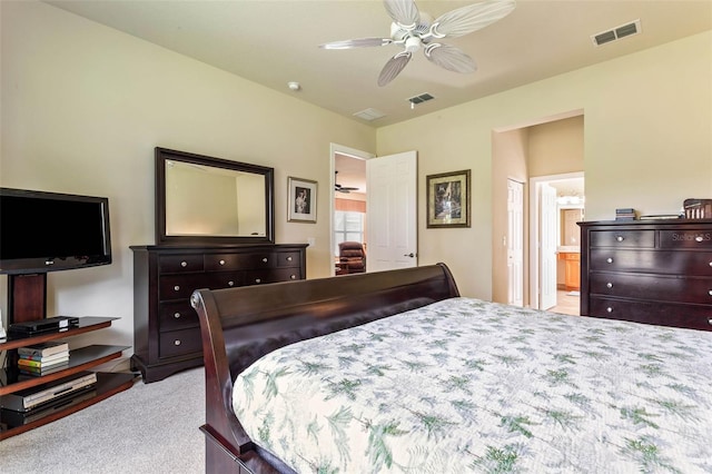 carpeted bedroom with ensuite bath and ceiling fan