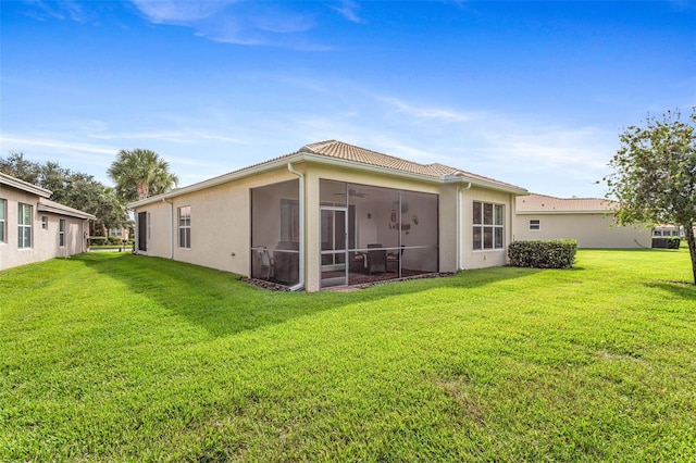 back of property featuring a lawn and a sunroom