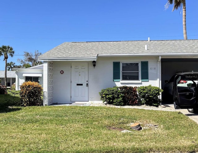 single story home featuring a carport and a front yard