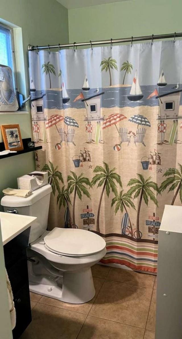 bathroom featuring vanity, toilet, walk in shower, and tile patterned flooring