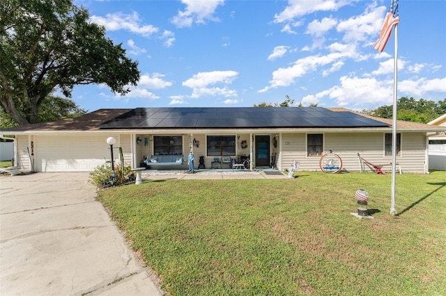 ranch-style home with a front yard, a garage, solar panels, and covered porch